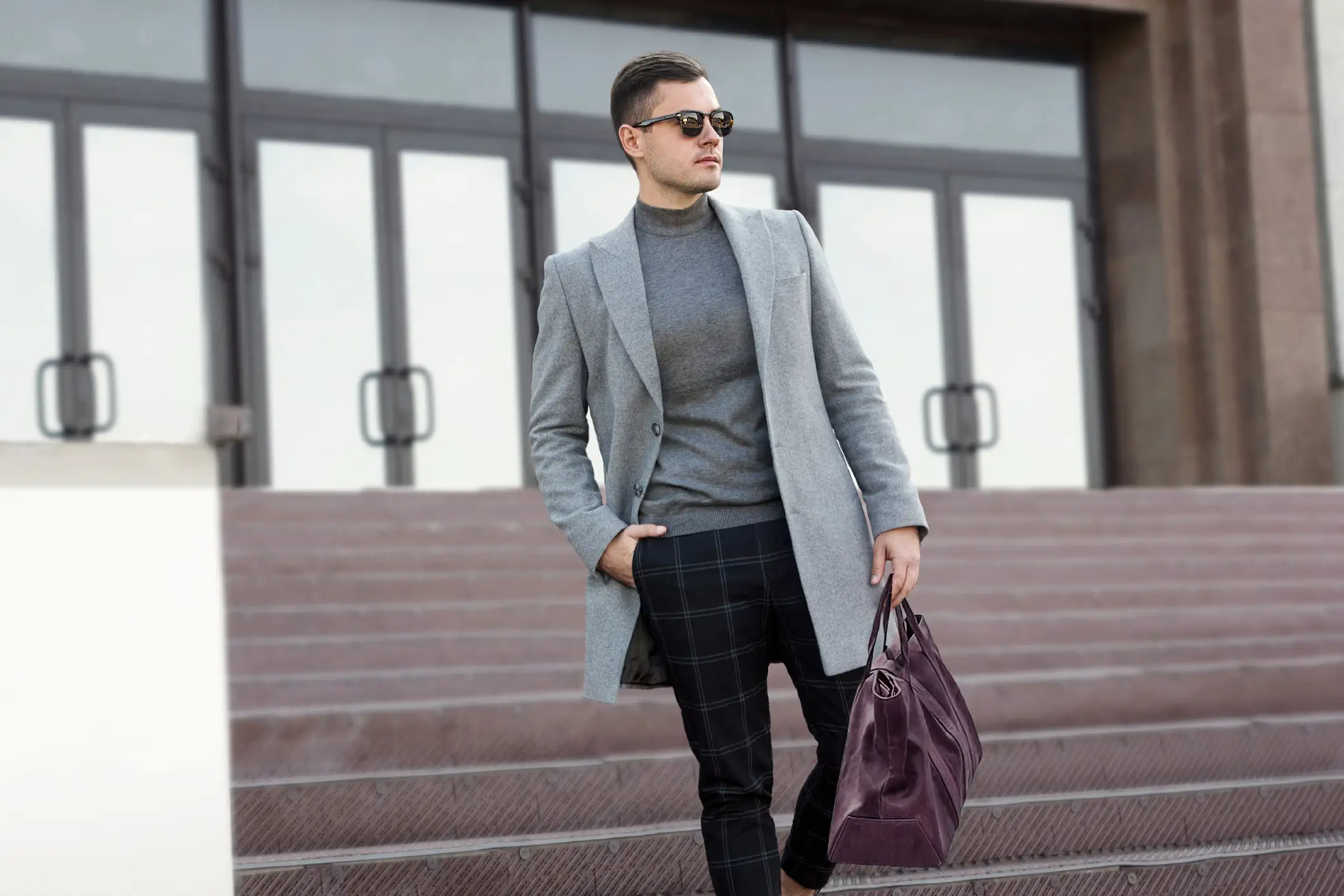 Man in stylish outfit with handbag.