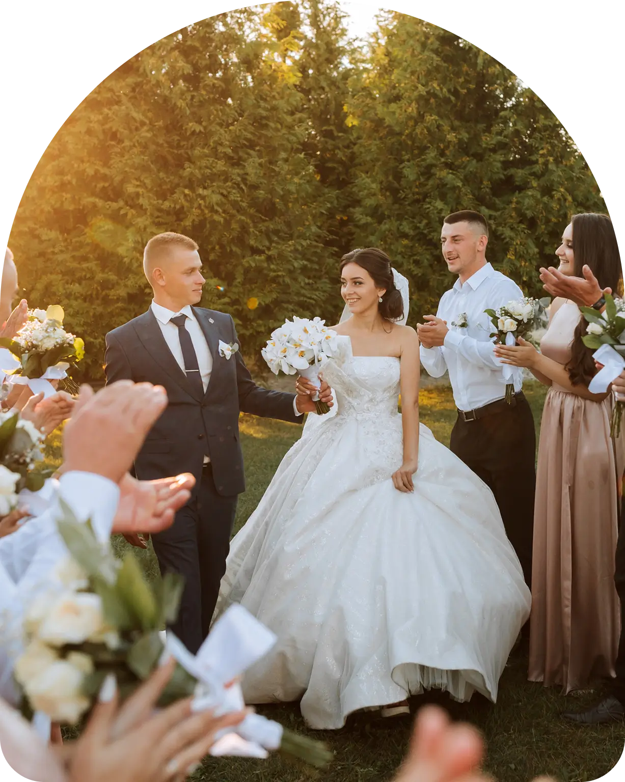 Bride and groom walking, guests applauding.