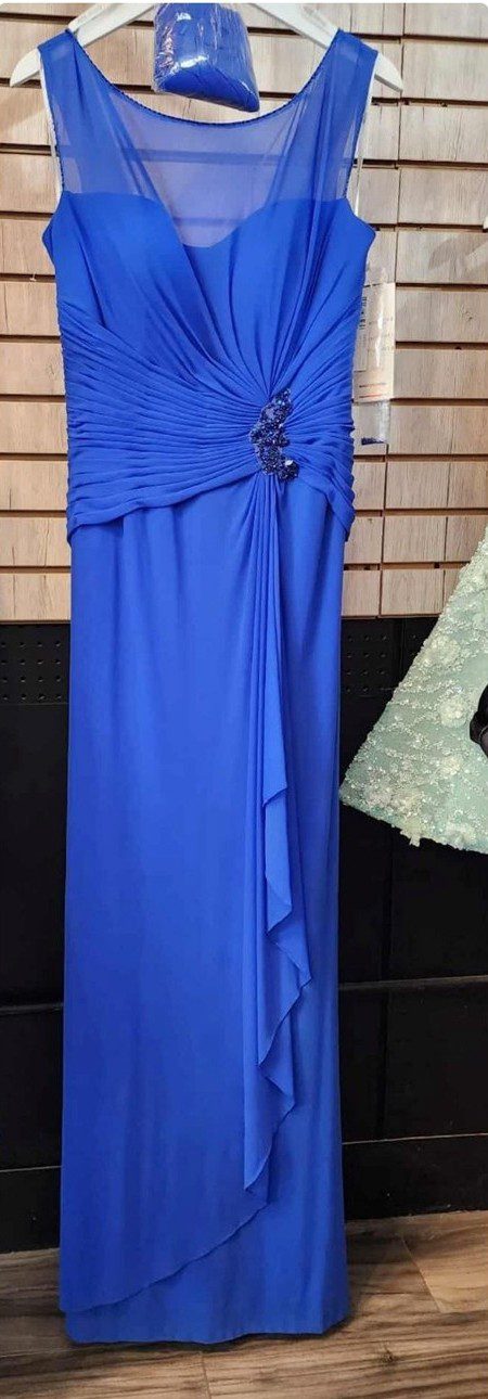 Elegant royal blue evening gown with draped detailing and a decorative brooch.