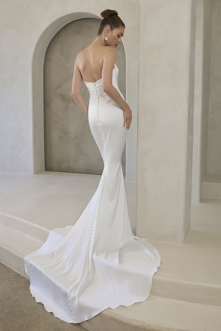 Elegant white mermaid-style wedding dress with a long train.